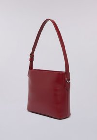 Borsa a mano in pelle rossa con una texture liscia, tracolla regolabile, forma rettangolare e dettagli circolari ai lati.