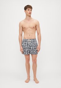 Schwarz-weiße Badeshorts mit floralem Muster, elastischem Bund mit Kordelzug und lässiger Passform.
