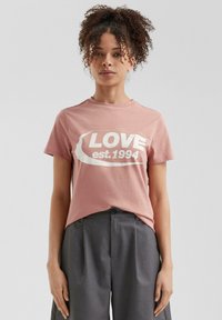 Lichtroze katoenen T-shirt met korte mouwen, voorzien van een opvallende witte "LOVE est. 1994" grafiek op de voorkant. Eenvoudige ronde hals.
