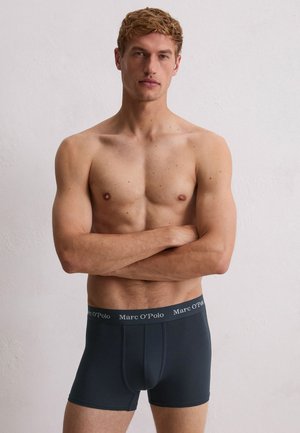 Dunkelgraue Boxershorts aus einem weichen, elastischen Stoff. Mit einem gebrandeten Bund, auf dem "Marc O'Polo" in weißer Schrift steht. Einfaches und figurbetontes Design.