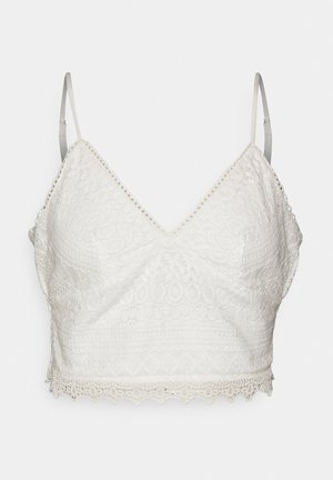 Weißes Spitzen-Bralette mit V-Ausschnitt, verstellbaren dünnen Trägern und gewelltem Saum. Es zeigt filigrane Blumen- und geometrische Muster.