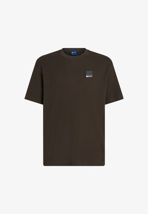 Tumepruun, lühikeste varrukatega t-särk, millel on tekstuuriga ribakiri, ümmargune kaelus ja vasakul rinnal väike must logo silt.