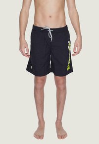 Shorts da nuoto neri con vita elasticizzata e lacci, caratterizzati da una grande stampa grafica verde sul lato sinistro e un piccolo etichetta con logo.
