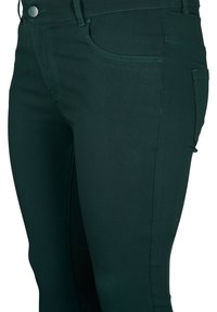 Tmavě zelené džíny se slim fit, s bočními kapsami a viditelnými švy. Materiál má hladkou, elastickou texturu.