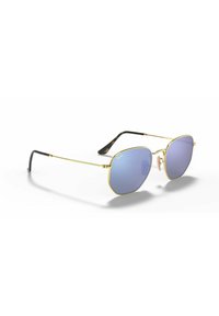 Occhiali da sole in metallo dorato con lenti blu, forma esagonale e punte degli occhiali in plastica nera. Dotati di un cuscinetto per il naso per maggiore comfort.