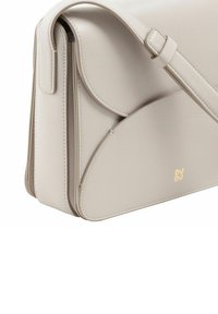 Bolso cruzado de cuero gris claro con cierre de solapa, formas curvas, costuras en contraste y un acento de logo dorado.