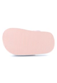 Semelle de chaussure en caoutchouc rose clair avec des rainures horizontales pour une meilleure adhérence ; bout arrondi et bords lisses, attachée à un corps en matériaux souples.