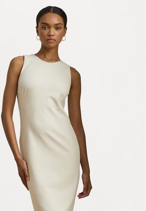 Robe sans manches, ajustée, de couleur crème, fabriquée en tissu lisse avec un col rond. Design simple sans motifs ni embellissements.