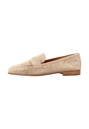 Mocasín beige de ante plano con tacón bajo de madera y pequeñas tachuelas redondas doradas a lo largo de los laterales y la correa superior.