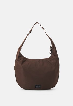 Sac d’épaule marron en forme de croissant avec une sangle réglable et une petite étiquette « Recycled » au centre devant sur un fond uni.