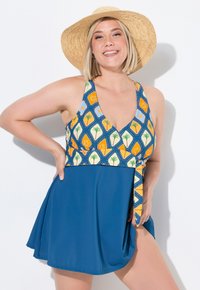 Uimapuku, jossa on kaula-aukko ja värikäs kuviollinen yläosa, jossa on keltaisia ja sinisiä motiiveja, sekä yksivärinen sininen hameosa.