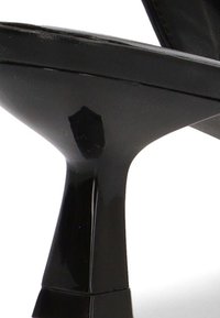 Zapato de tacón alto negro brillante con un tacón estrecho y afilado y una suela lisa visible.