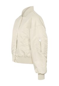 Veste bomber crème avec une texture lisse, col et poignets côtelés, poches latérales et une poche zippée sur la manche gauche.