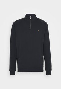 Zwarte sweatshirt met een hoge kraag met rits, geribbelde manchetten en onderrand. Voorzien van een klein gouden logo op de borst. Zacht, gladde textuur.