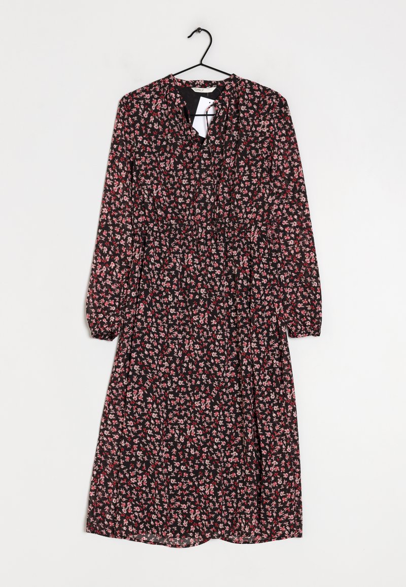 Robe noire avec un motif floral rose et blanc. Manches longues, taille froncée et décolleté rond. Suspendue à un crochet noir.