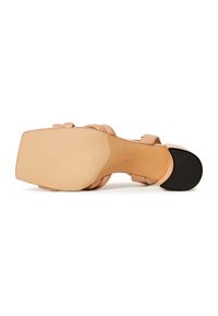 Nude korkeakantaiset sandaalit, joissa on litteä pohja ja sileä nahkapinta. Varustettu pyöreällä varpaalla, säädettävällä nilkkahihnalla ja hienovaraisilla ompeluista.