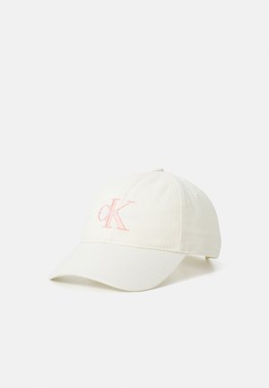 Hvid baseballkasket med lyserødt Calvin Klein-logo broderet foran, vist på en ensfarvet hvid baggrund.