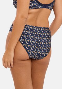 Navy bloemetjes bikini onderstuk met kleine, gekleurde bloemetjes. Hoge taille ontwerp, zachte textuur en gladde afwerking; beschikt over minimalistische hardware.