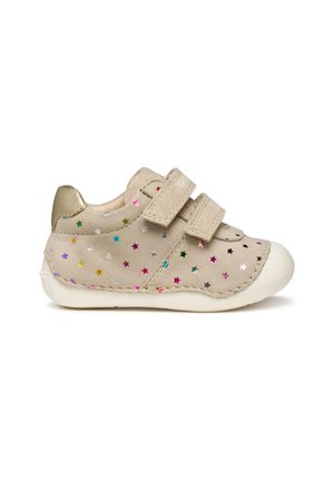 Chaussure en daim beige avec deux bandes Velcro, semelle en caoutchouc blanche et motifs d'étoiles colorés en rose, bleu, vert et argent. Accent de talon doré.