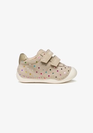 Scarpa in suede beige con due strappi in Velcro, suola in gomma bianca e motivi a stella colorati in rosa, blu, verde e argento. Accent del tacco dorato.