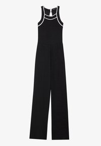 Combinaison noire à jambes larges, texture côtelée et bordures blanches. Elle présente un col haut et une fermeture en forme de trou de serrure dans le dos.