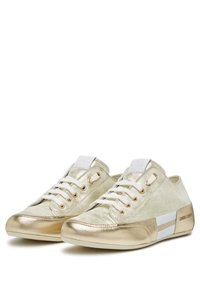Sneaker metallic dorate con tomaia in suede crema, lacci bianchi e dettagli in oro. Presentano una punta lucida e accenti a righe sui lati.