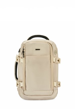 Sac à dos rectangulaire beige avec poche zippée à l'avant, poignée rembourrée noire sur le dessus et le côté, sangles de compression latérales avec boucles.