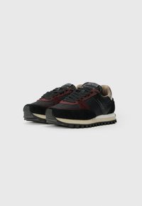 Pair of low-top black and dark red sneakers with textured rubber soles and black laces, shown on white background.