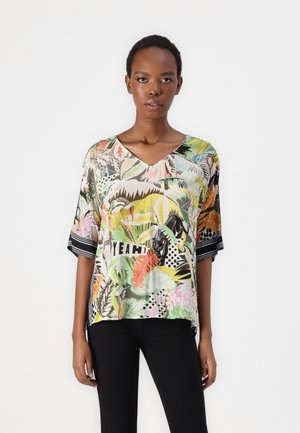 Short-sleeve V-neck top in lightweight fabric. Features colorful botanical print with a black and white striped accent. Text reads "YEAH!"