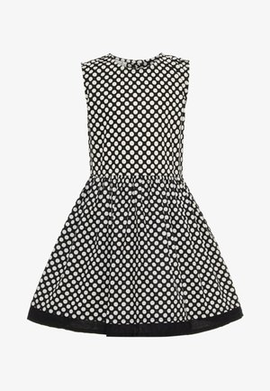 Robe noire sans manches à pois blancs, taille ajustée et jupe évasée avec bordure noire à l'ourlet.
