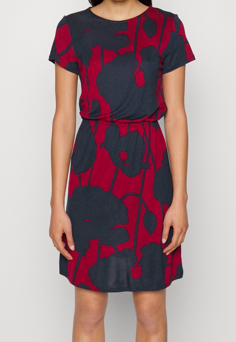 Robe à manches courtes en tissu doux, avec une base bleu marine ornée de grands motifs floraux rouges et une taille cintrée pour une silhouette flatteuse.