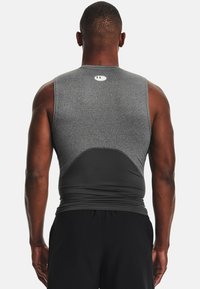 Gray sleeveless athletic shirt featuring a fitted design, smooth texture, and contrasting black lower panel with logo detail near the neckline.