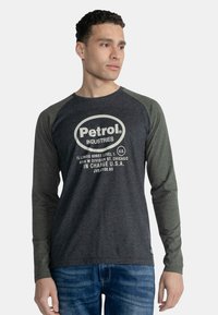 Langærmet raglan t-shirt i mørkegrå og gr�øn, med et hvidt trykt logo og tekst på fronten. Materiale af bomuldsblanding.