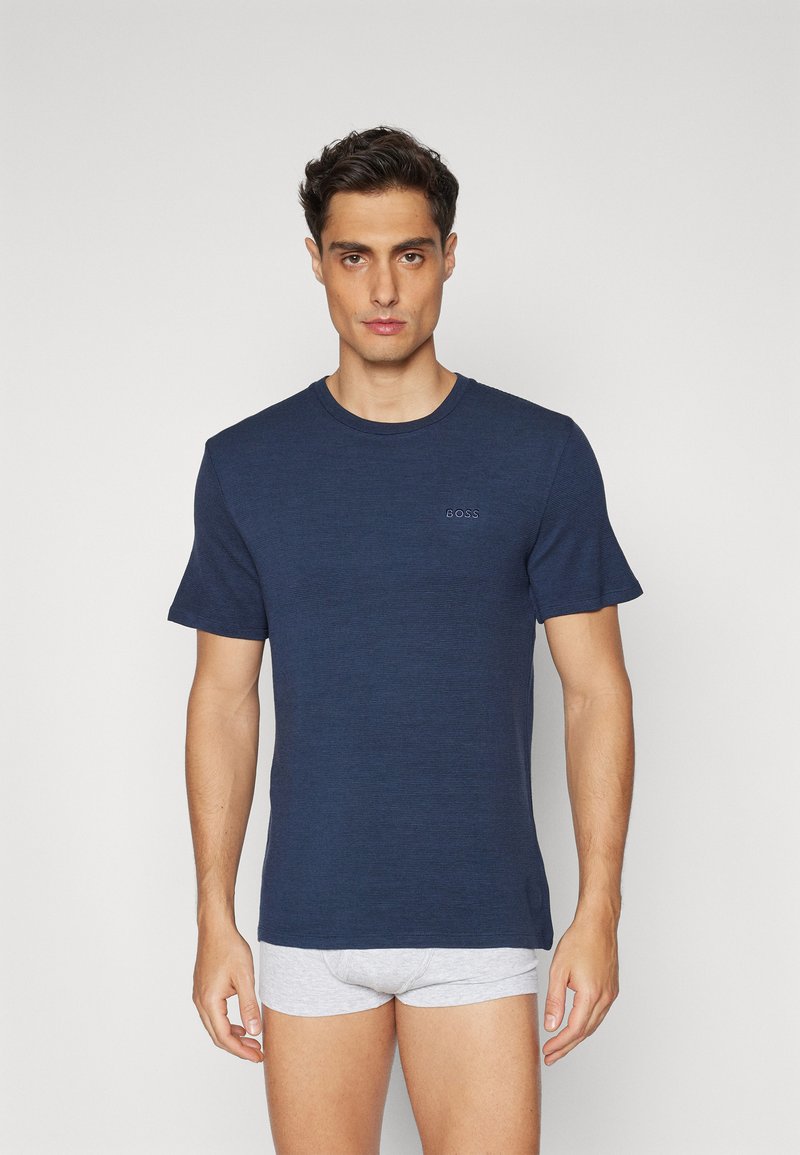 T-shirt de manga curta azul marinho em tecido texturizado com decote redondo. Apresenta o logótipo BOSS discreto no peito e um corte descontraído.