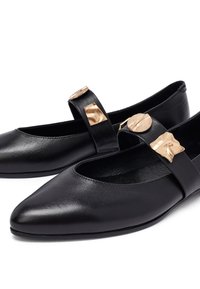Ballerine in pelle nera con punte appuntite, dotate di una cinturino decorato con dettagli geometrici in tono oro. Texture liscia e design minimalista.