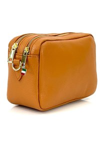 Tan lederen cosmeticatas met een getextureerd oppervlak, dubbele ritsen, gouden hardware en een klein accent van de Italiaanse vlag. Compact rechthoekige vorm.