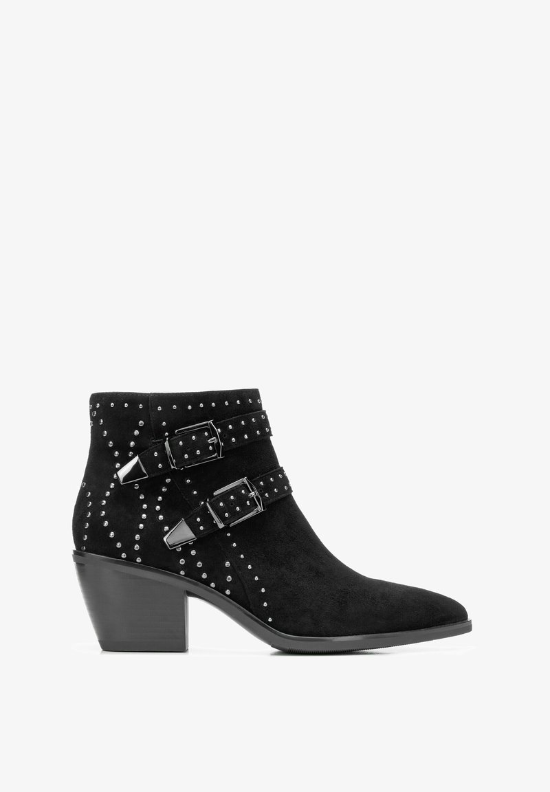 Zwarte suède enkellaars met lage blokhak, twee gespen met studs en decoratieve zilveren studs langs de zijkanten en achterkant.