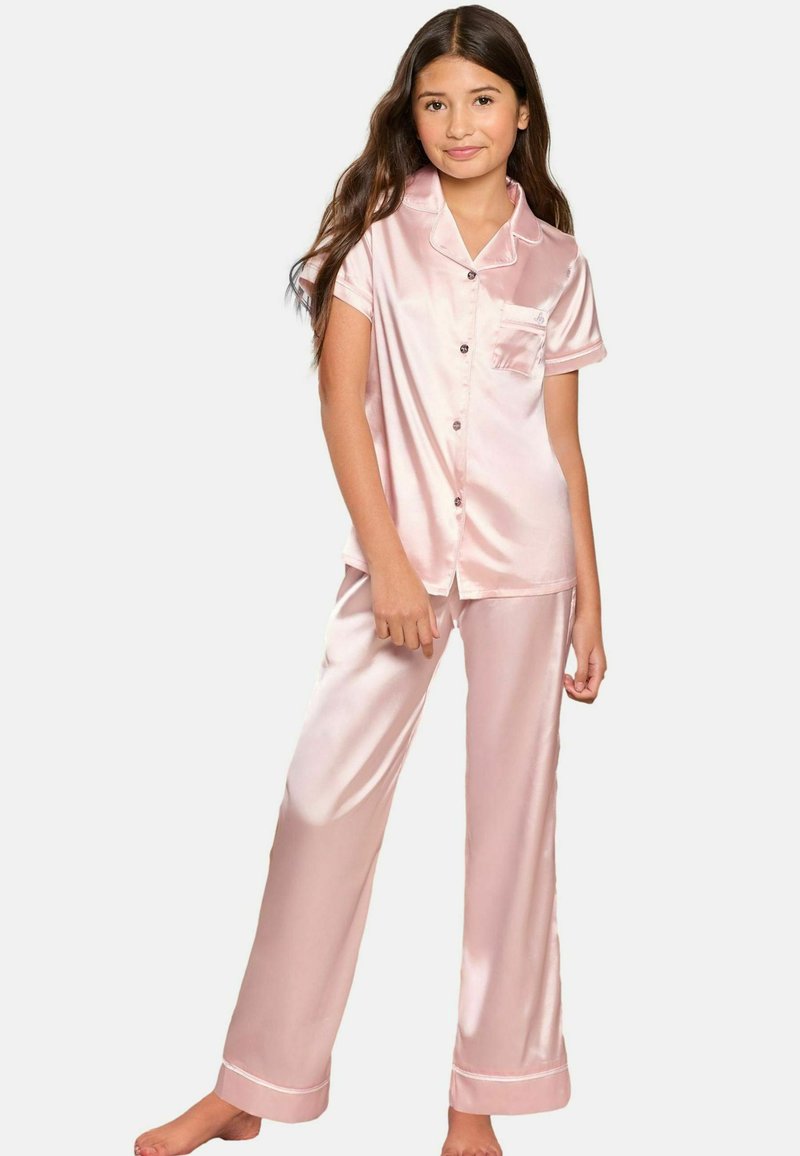 Rosa satinpyjamasset som består av en kortärmad knäppblus med en ficka och långa byxor med uppvikt fåll. Slät textur, glansig yta.