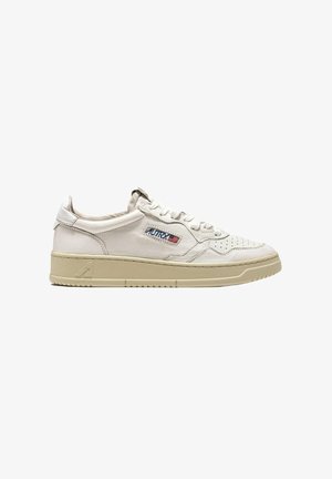 Sneaker in pelle bianca con design strutturato, punta traforata e suola in gomma beige. Presenta il marchio "AUTRY" in rosso e blu.