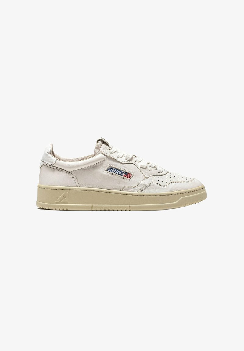 Sneaker in pelle bianca con design strutturato, punta traforata e suola in gomma beige. Presenta il marchio "AUTRY" in rosso e blu.