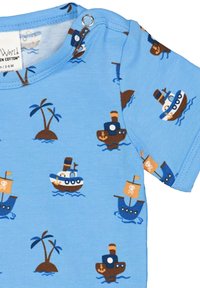 Camicia di cotone blu con stampa a tappeto di navi, isole e palme. Presenta una chiusura a scatto sulla spalla per facilitare la vestizione.