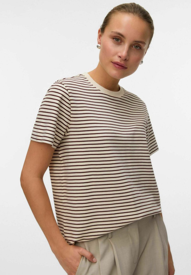 Randig t-shirt i creme med vinröda horisontella linjer. Mjukt tyg, korta ärmar, rund halsringning, avslappnad passform. Försedd med subtila sömnadsdetaljer.