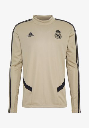 Beige sporttop met lange mouwen en een hoge kraag, met een zwart Adidas-logo en donkere zijstrepen. Heeft mesh accenten bij de zakken.