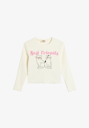 Weiße, gerippte Langarmshirt mit dem Text "Best Friends" in Pink und Illustrationen von zwei Katzen, einer schwarz-weiß, mit Schnurrhaaren.