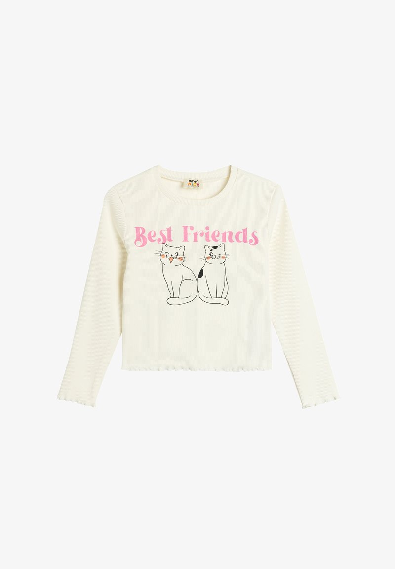 Weiße, gerippte Langarmshirt mit dem Text "Best Friends" in Pink und Illustrationen von zwei Katzen, einer schwarz-weiß, mit Schnurrhaaren.