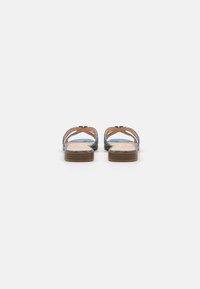 Brown flat sandals with blue detailing, open toe design, two straps with cut-out accents, and a light brown textured sole.