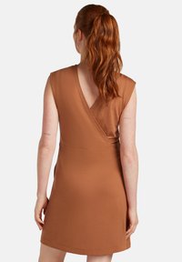 Bruine wikkeljurk met korte mouwen en een V-hals. Gemaakt van zachte stof, met een getailleerde taille en een uitlopende rok.