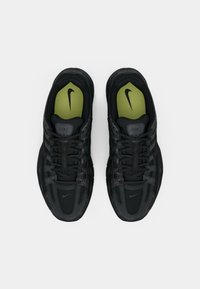 Melni sporta apavi ar teksturētu sietu un sintētiskajām virsmas daļām. Zaļās zolītes un melnie auklas. Satur Nike zīmolu uz mēles un sāniem.