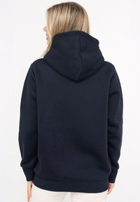 Dunkelblauer Hoodie mit einer großen Kapuze, hergestellt aus einem weichen Textilmaterial. Verfügt über gerippte Manschetten und einen gerippten Saum für eine enge Passform.