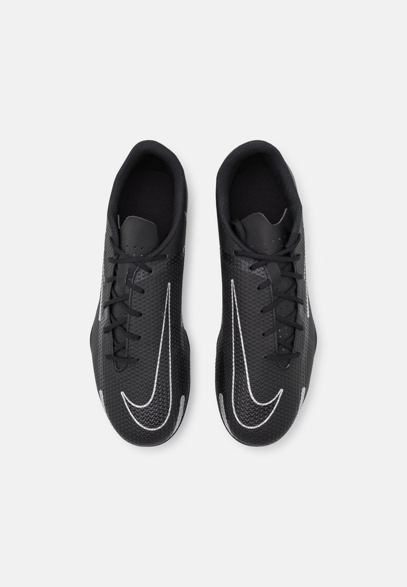 Zapatillas deportivas negras con una superficie texturizada, punta redondeada, cordones planos y un prominente swoosh blanco a cada lado.